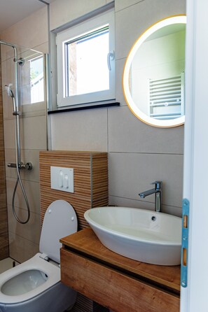 A modern bathroom with a toilet, sink, and shower. - ARIA Deluxe Mobile home with tickets (Brežice)