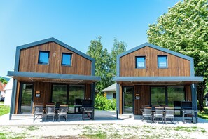 Two modern wooden buildings with large windows and outdoor seating areas. - ARIA Deluxe Mobile home with tickets (Brežice)