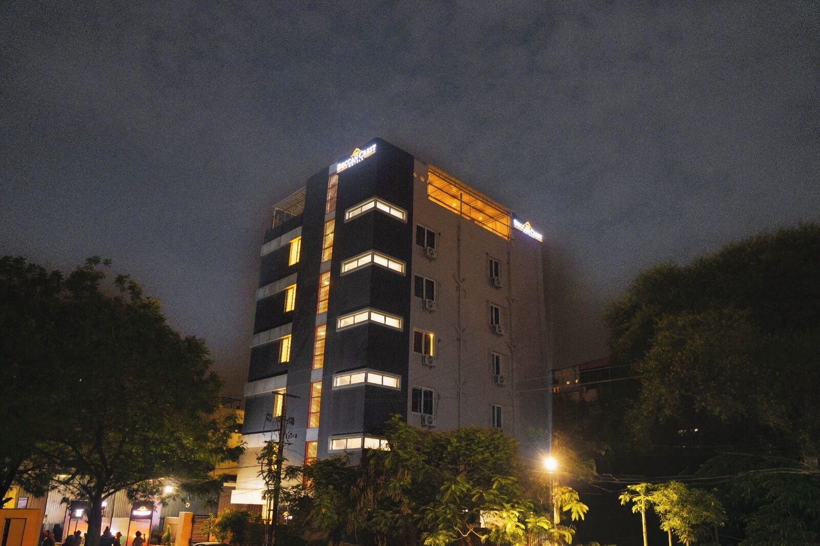 Un hotel de varios pisos con ventanas iluminadas y un cartel que indica que es un hotel.