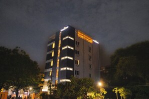 Un hotel de varios pisos con ventanas iluminadas y un cartel que indica que es un hotel.