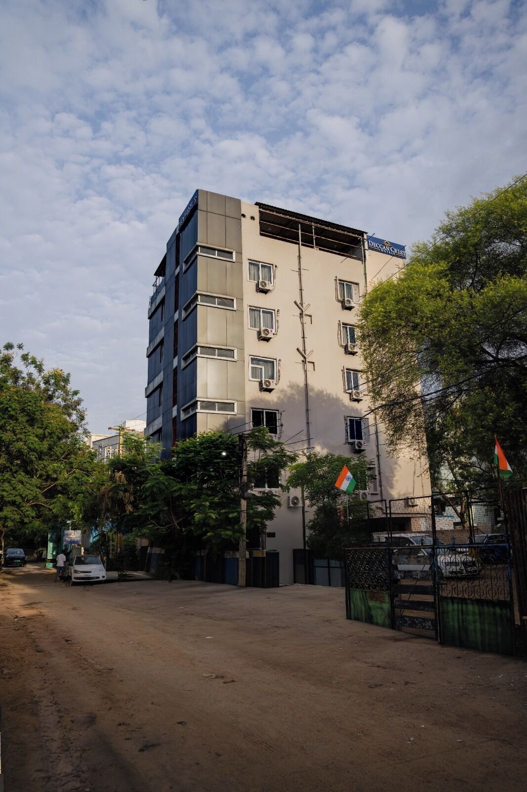 Un edificio de varios pisos con fachada plana, múltiples ventanas y una bandera.