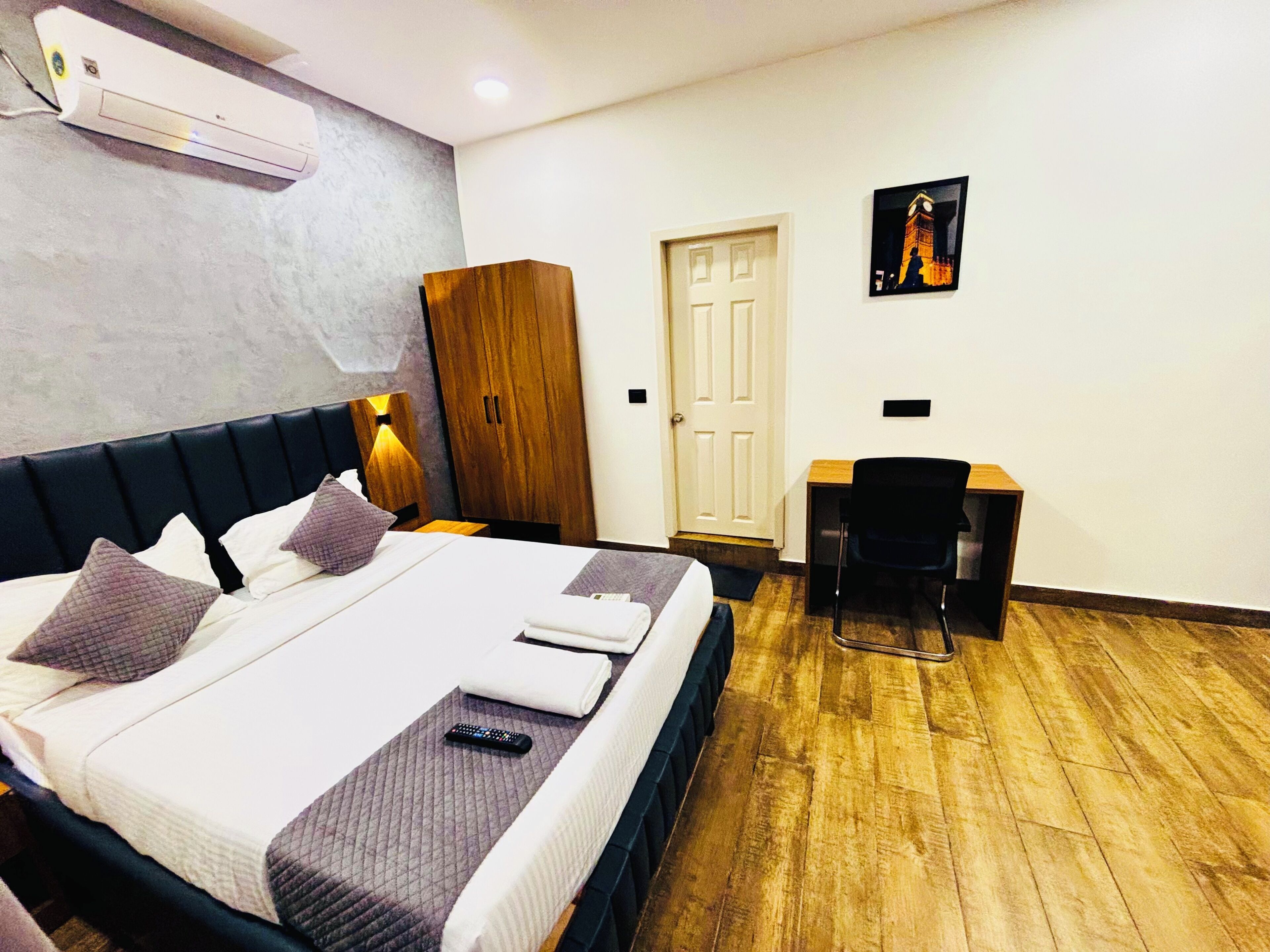 Una habitación de hotel con una cama, un escritorio, un armario y una puerta.