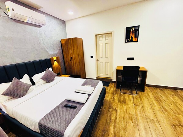 Una habitación de hotel con una cama, un escritorio, un armario y una puerta.