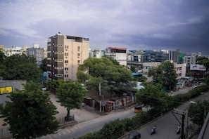 Un paisaje urbano con edificios de varios pisos, una calle con vehículos y árboles.