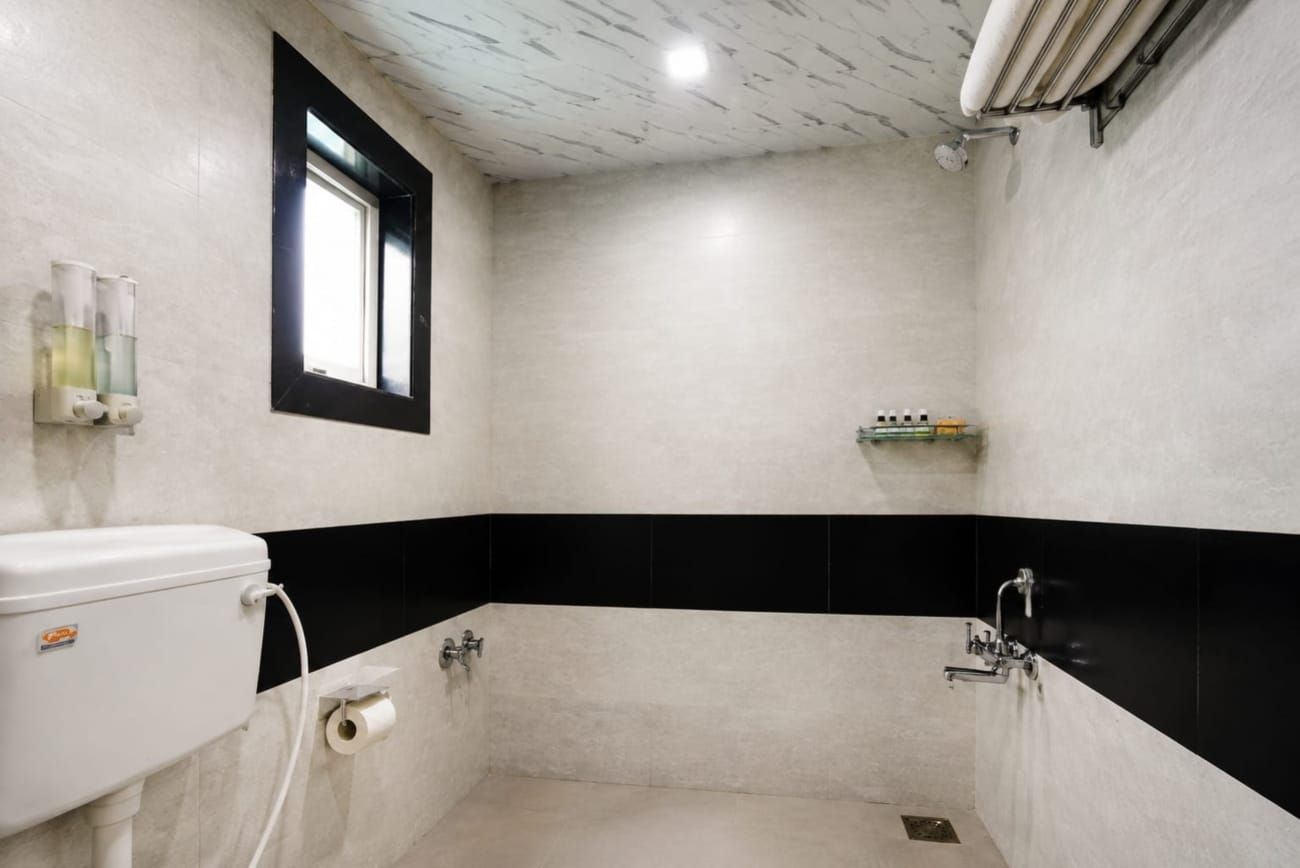Un baño pequeño y cerrado con inodoro, lavamanos y zona de ducha.