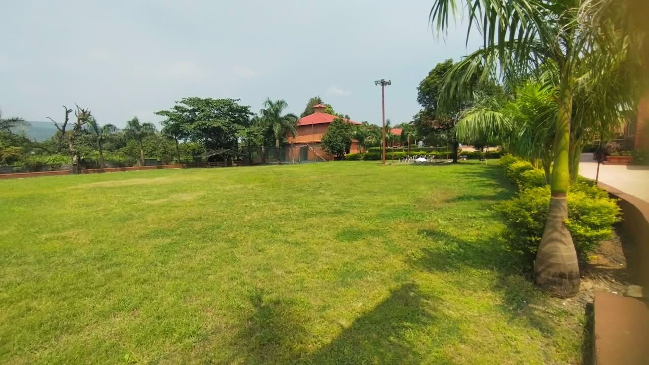 Un espacio al aire libre con césped y un edificio al fondo.