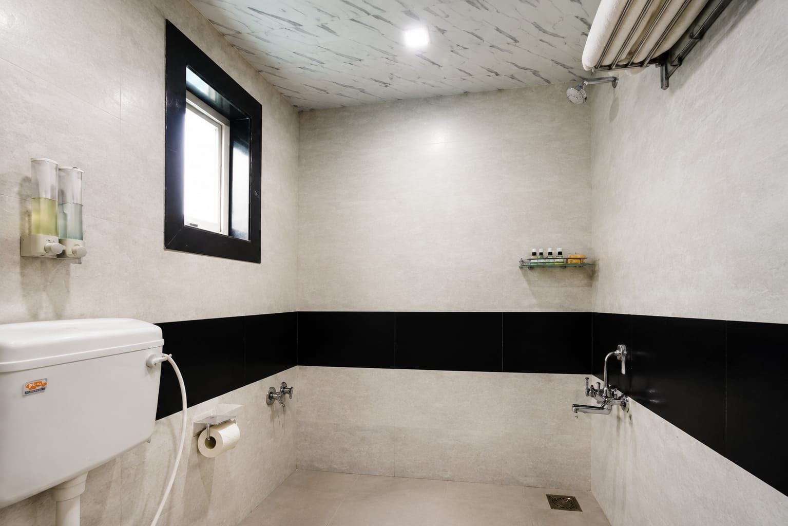 Un baño pequeño con azulejos, un inodoro, lavamanos y ducha.