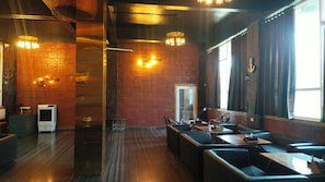 A restaurant with brick walls, wooden flooring, and a casual seating arrangement. - Shauryawada Resort, Alibag (Alibag)