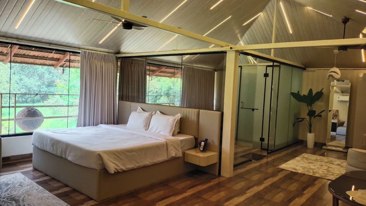 A modern bedroom with a large bed, bedside tables, a mirror, and a view of the outdoors.