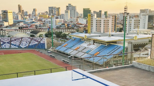 Une piscine sur le toit offrant une vue sur un stade et le paysage urbain.