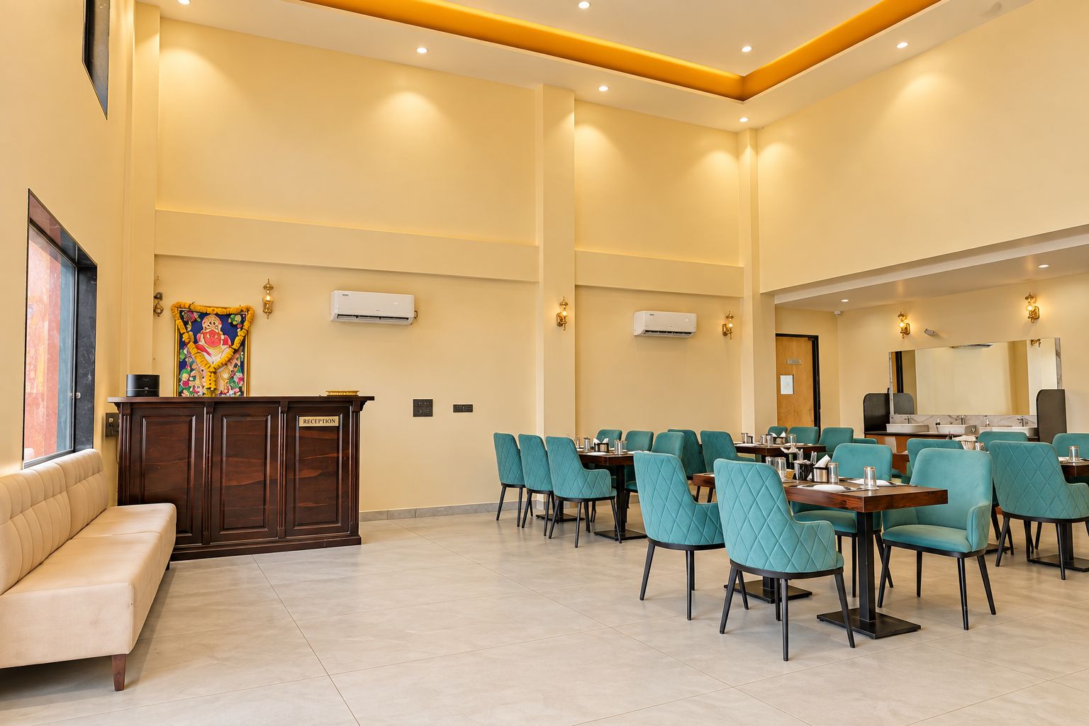 A hotel reception area with a reception desk, a sofa, and a dining area with tables and chairs.