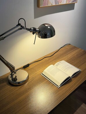 Een bureau met een lamp en een open boek.