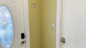 A corner of a room with a white door, a glass door with a decorative design, and a wall with a light yellow color.