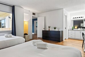 A hotel room with two beds, a dresser, a mirror, and a kitchenette. - Sunny Isles Condo • Shared Pool + Private Balcony • Near Beaches | Isle Vista (Sunny Isles Beach)