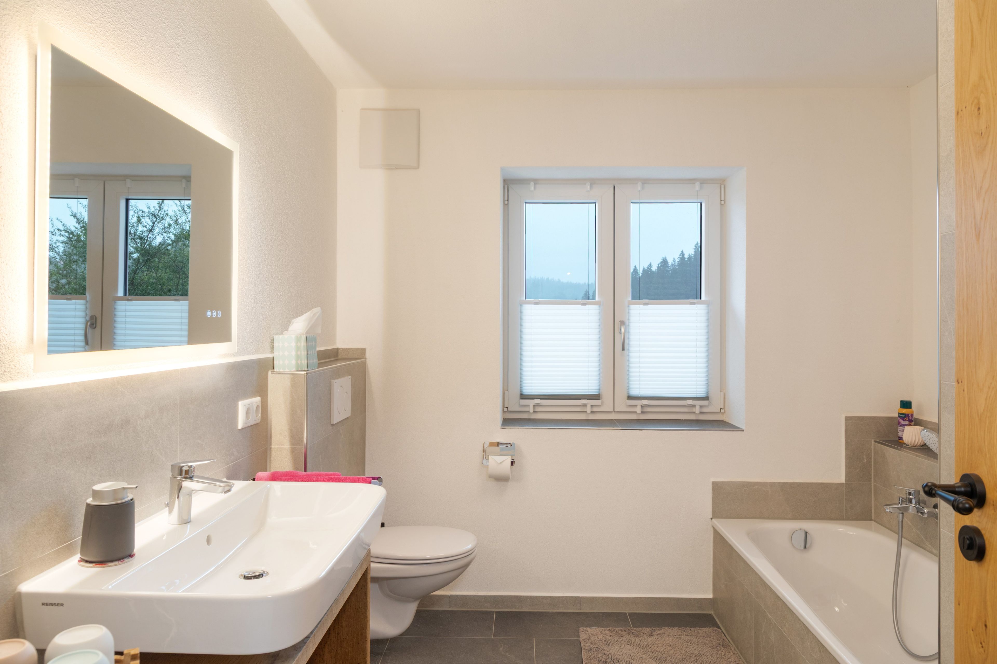 Ein modernes Badezimmer mit Waschbecken, Toilette und Badewanne.