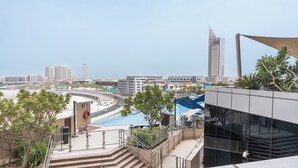 A high-rise building with a pool and a view of the cityscape. - StayShort - Dubai Media City sleeps 2 with Amazing Sea Views! (Media City)