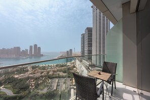 Ein Balkon mit Blick auf eine Stadtlandschaft, darunter hohe Gebäude und ein Gewässer.