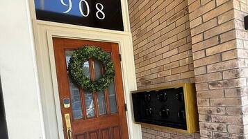 A wooden door with a wreath, a sign above reading 'THE 908', and a 'UNION BLOCK' mat at the entrance.