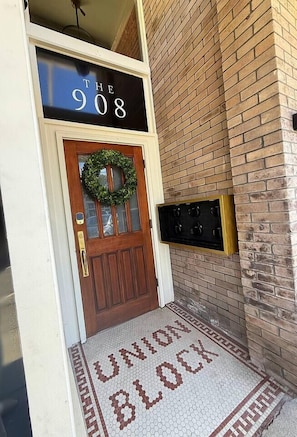 A wooden door with a wreath, a sign above reading 'THE 908', and a 'UNION BLOCK' mat at the entrance. - Suite 3 · Historic Snohomish 1st St (Snohomish)