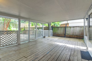 A covered patio area with a wooden deck, white railings, and a view of a backyard with a wooden fence and trees. - 2-Unit Combo 10 Mi to Vintage Park & Airport! (Houston)