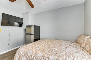 A bedroom with a bed, a television mounted on the wall, and a refrigerator. - 2-Unit Combo 10 Mi to Vintage Park & Airport! (Houston)