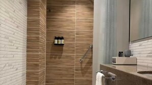 Un baño moderno con inodoro, ducha y tocador.