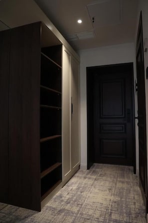 Un pasillo con un armario de madera oscura, una puerta con diseño de panel y una alfombra estampada.