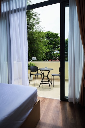 A room with a bed, a table, and chairs, with a view of greenery outside. - Near Ben Thanh Market: 2 Beds Apt by D Haus with Netflix (Thành phố Hồ Chí Minh)
