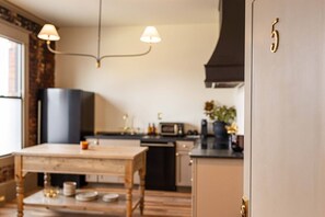 Eine Küche mit Esstisch, Mikrowelle und Schrank.