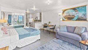 A modern hotel room with a bed, a sofa, a dining table, and a kitchen area. - Modern Designer Studio in Waikiki near Ala Moana (Honolulu)