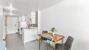 A modern kitchen with white cabinetry, a built-in microwave, and a tiled backsplash. - Modern Designer Studio in Waikiki near Ala Moana (Honolulu)