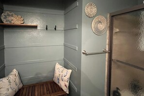 A room with a wooden bench, a door, and decorative wall art. - Group-Friendly Rambler w/ Fenced Backyard & Deck (Toledo)