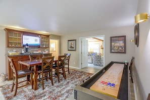 A dining area with a pool table, wooden chairs, and a kitchen with a digital screen. - Group-Friendly Rambler w/ Fenced Backyard & Deck (Toledo)