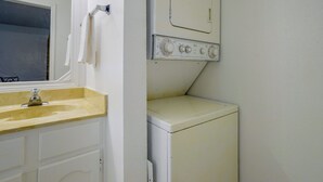 Ein kleiner Hauswirtschaftsraum mit Waschmaschine, Trockner und Waschbecken.