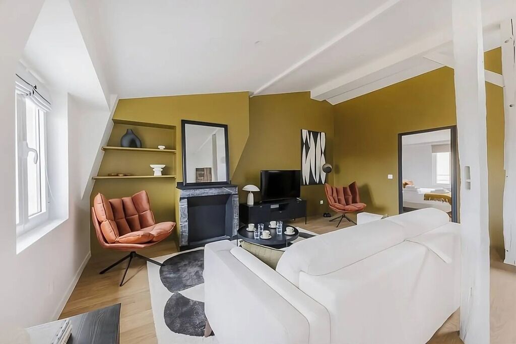 A modern living room with a fireplace, a television, and a sofa.