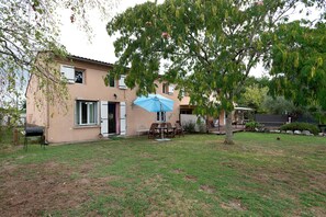 A house with a patio, a blue umbrella, and a tree. - Gîte de Bossuet – Wi-Fi, Garden & Air Conditioning near Bordeaux & Atlantic Coast (Saint-Denis-de-Pile)