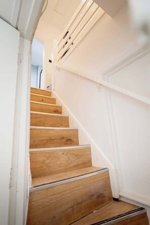 Eine Holztreppe mit weißen Wänden und einer Handlauf.