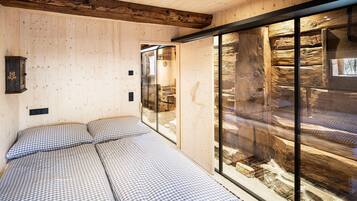 Una habitación con una cama, pared de madera y un ventanal grande.