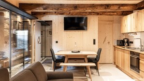 A modern kitchen with wooden cabinets, a built-in oven, and a coffee maker. - Elegant Apartment in a Converted Stable (Matrei in Osttirol)