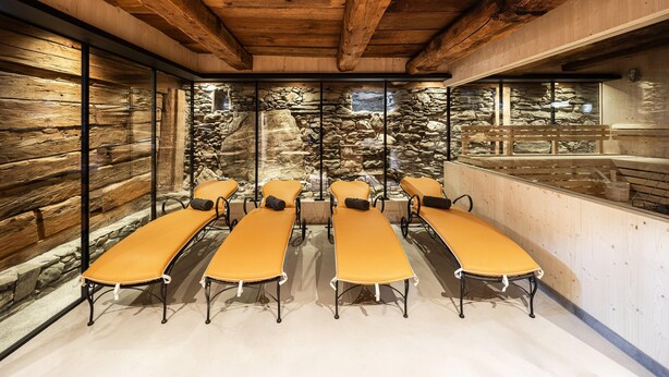 A room with wooden beams, stone walls, and a stone waterfall feature. - Elegant Apartment in a Converted Stable (Matrei in Osttirol)