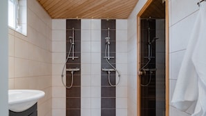 A bathroom with a shower, a sink, and a towel rack.