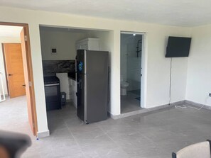 A modern kitchen with a refrigerator, stove, and cabinets. - Rico Puerto magic spot oeste (Cabrera)