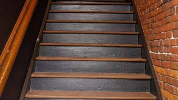 A staircase with wooden steps and a brick wall on one side.