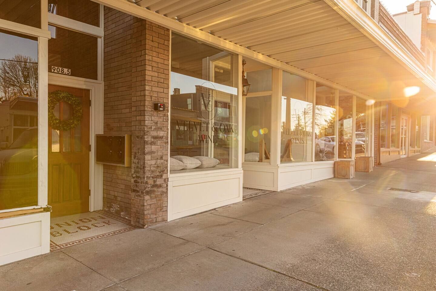 A hotel entrance with a brick facade, large windows, and a covered walkway.