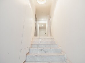 Eine Treppe mit Marmorstufen, die zu einer Tür oben führt.