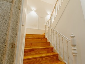 A staircase with wooden steps and white balusters. - Apartment  by Interhome (Porto)