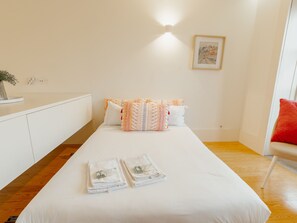 Une chambre d’hôtel avec un lit, des oreillers, une table de chevet, une lampe et un tableau au mur.