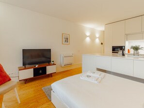A modern hotel room with a bed, a TV, a small desk, and a bathroom area. - Apartment  by Interhome (Porto)
