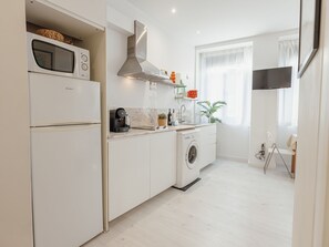 A modern kitchen with a built-in oven, microwave, and washing machine. - Apartment  by Interhome (Porto)