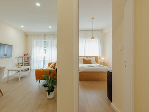 Ein modernes Hotelzimmer mit Bett, Nachttisch, Lampe und einem Topfpflanzen.